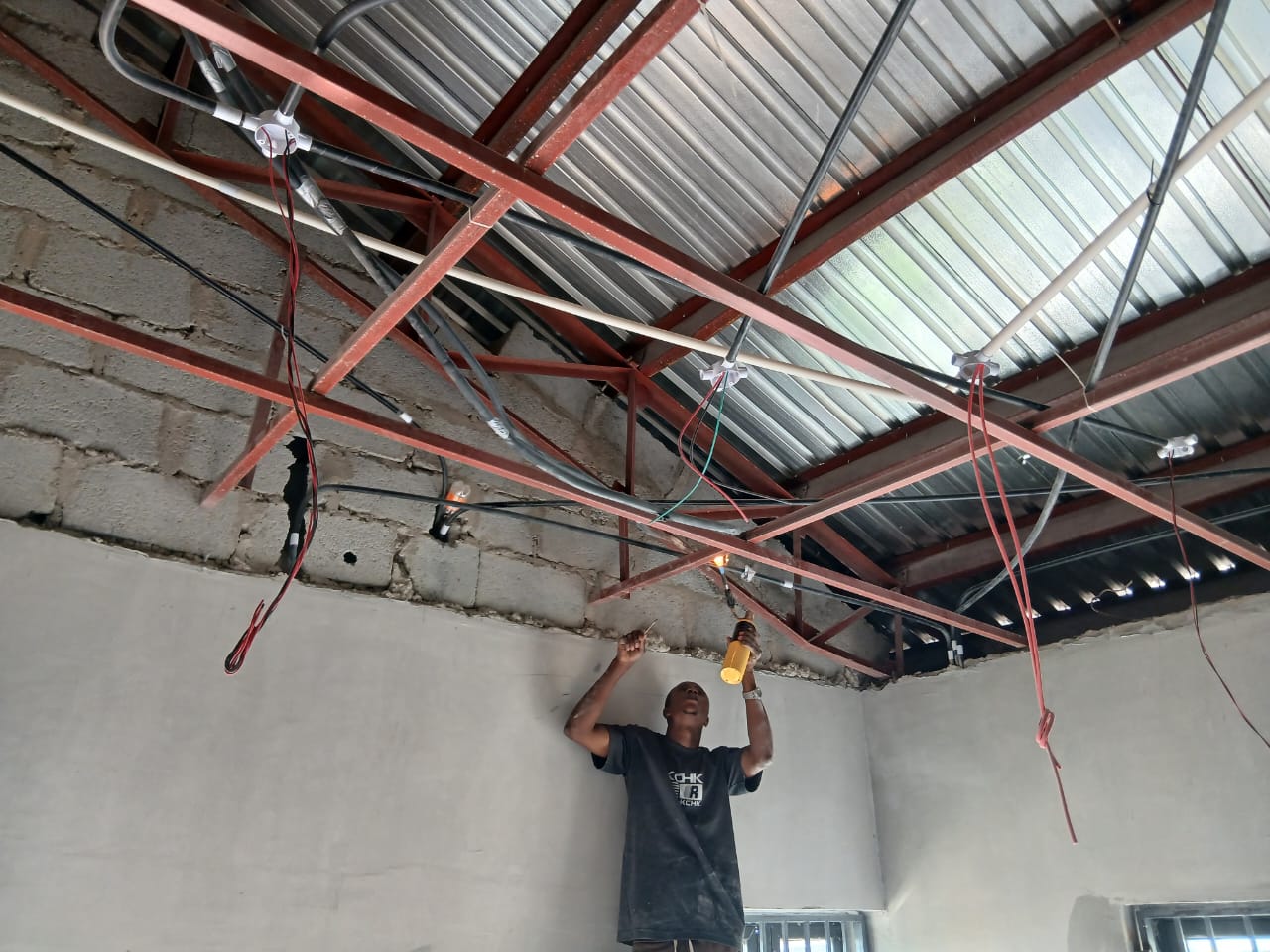 Technician inspecting services along the roof steel