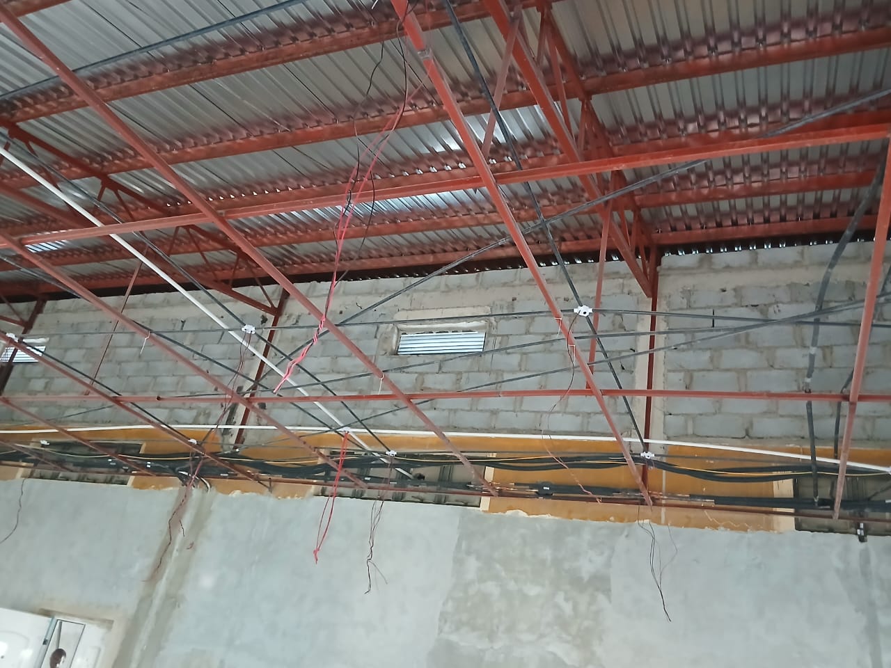 Insulated pipework routed along steel roof trusses